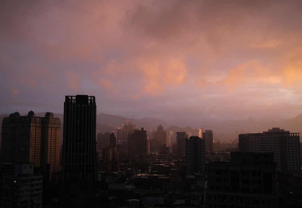 a view of a city at sunset with clouds in the sky