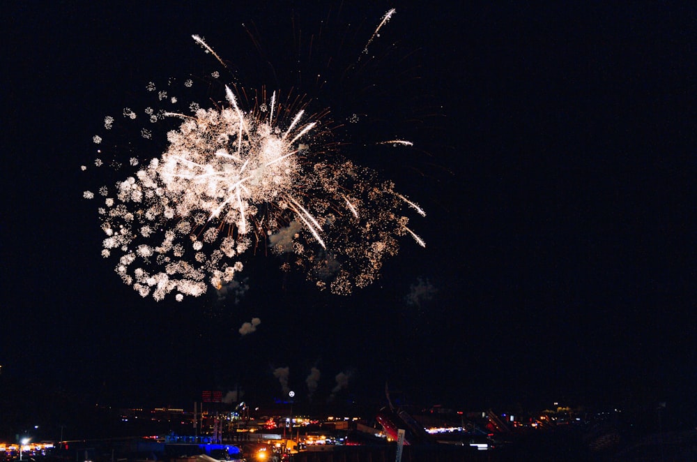 a fireworks display in the night sky over a city