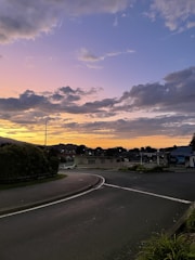 A monochrome photo with purple accents highlighting a quiet street at dusk.