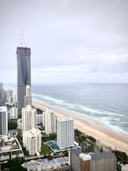 Construction site with workers building a residential structure in a coastal town.