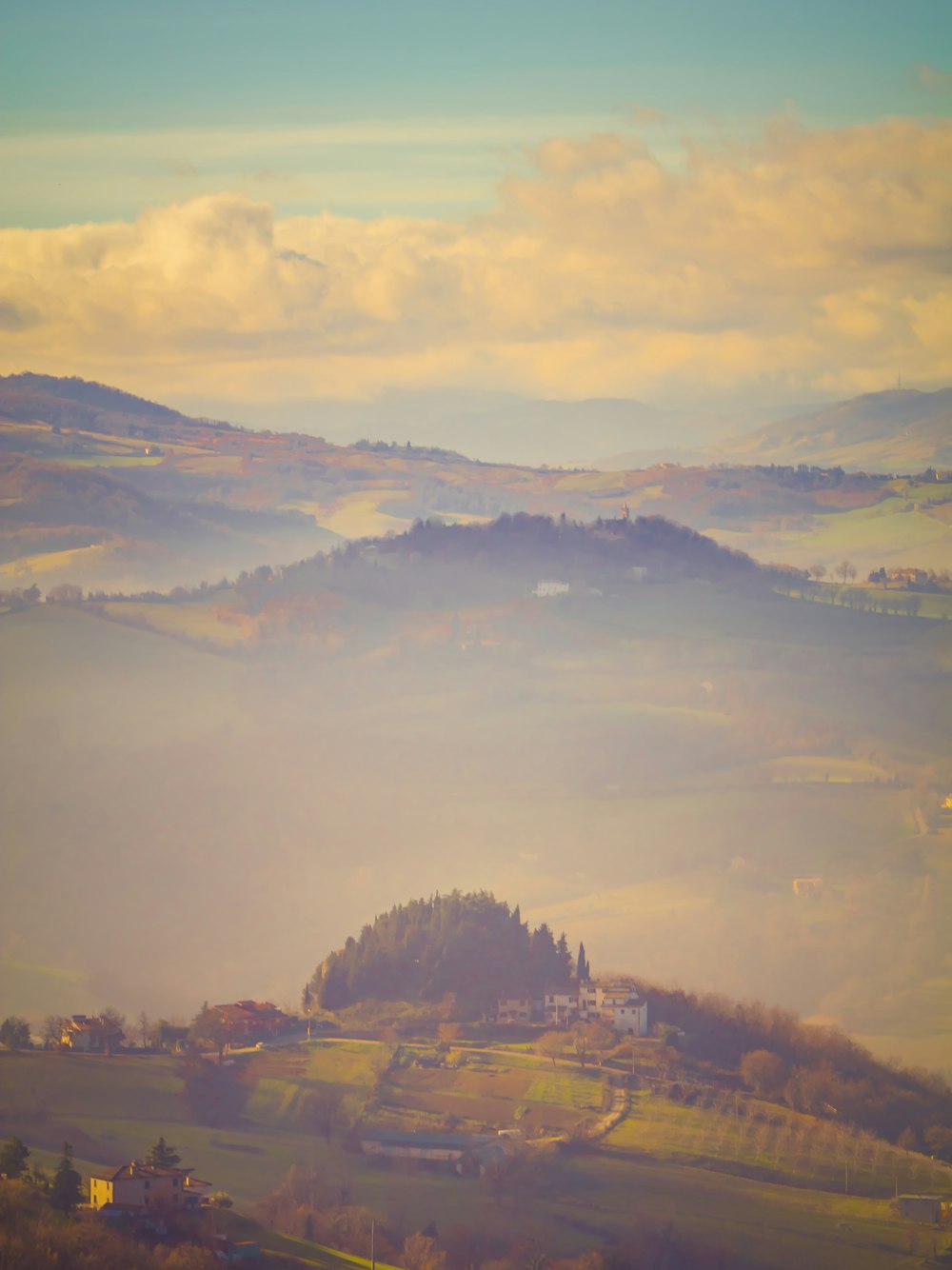 a foggy landscape with a small island in the middle