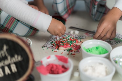a group of children sitting around a table with doughnuts