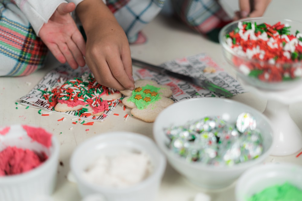 a person is decorating a cookie on a table