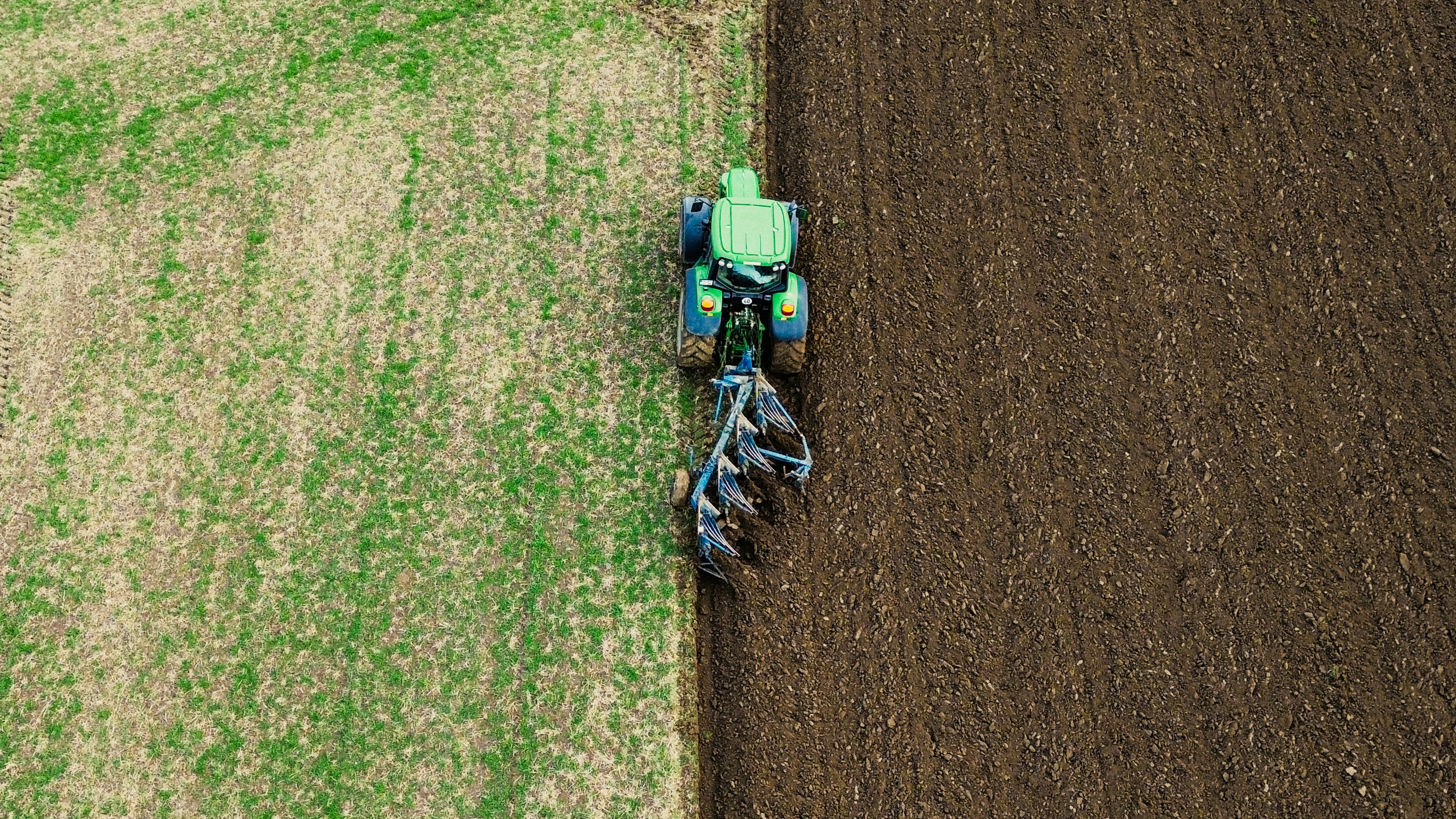 a tractor is plowing a field of grass