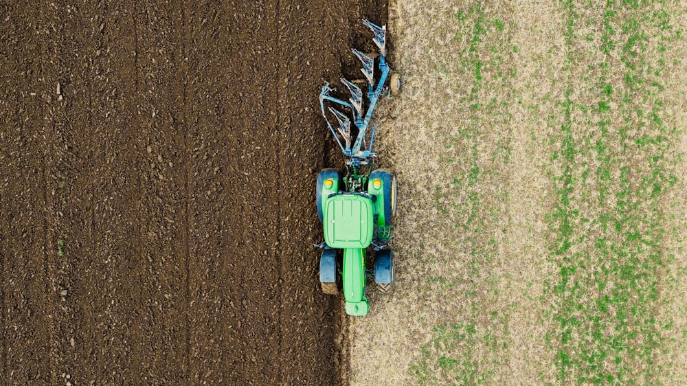 Ein Traktor pflügt ein Grasfeld