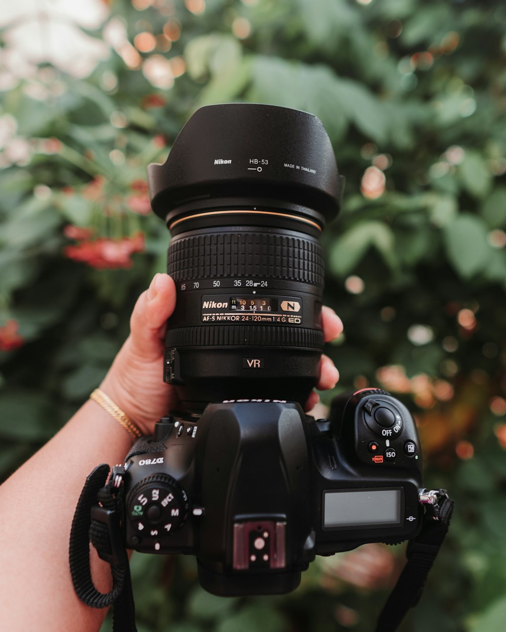 a person holding a camera with a lens attached to it