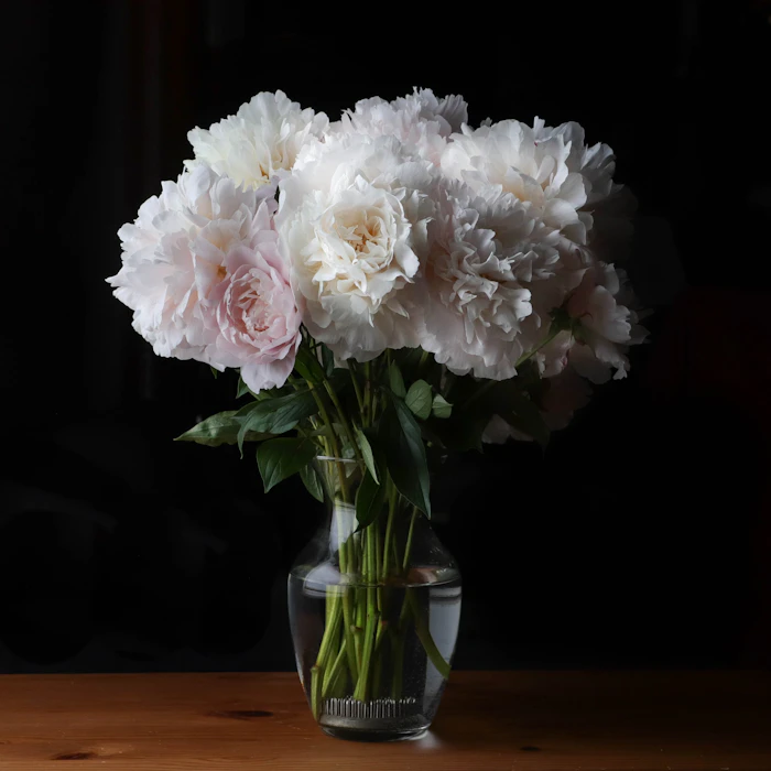 A vase of white flowers on a wooden table