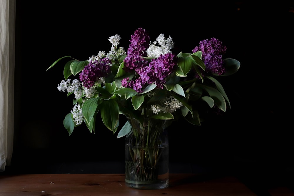 a vase filled with purple and white flowers