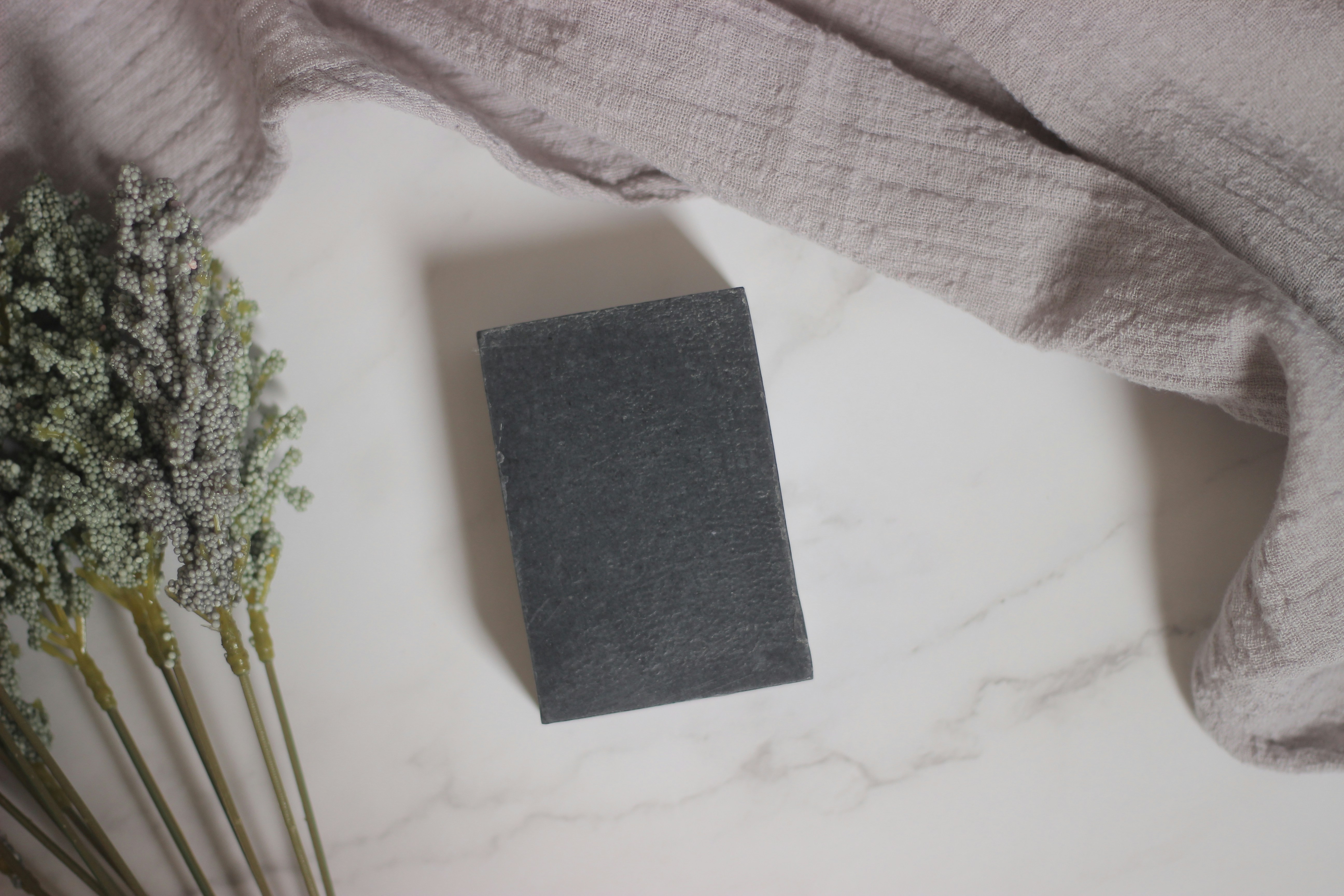 Un libro grigio seduto sopra un tavolo accanto ai fiori