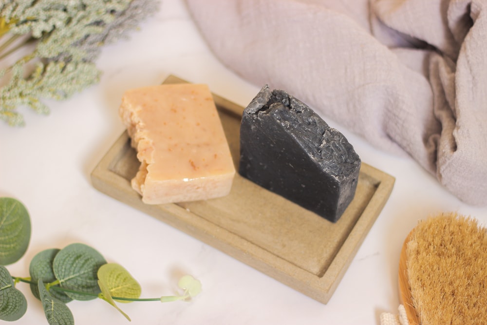 a couple of soaps sitting on top of a wooden tray