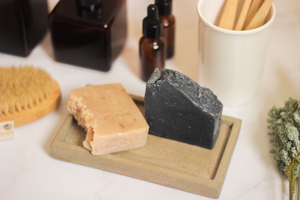 a couple of soaps sitting on top of a wooden tray