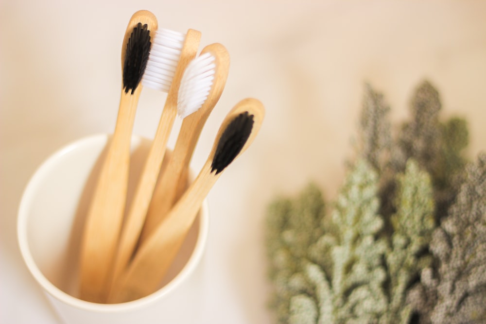 four toothbrushes in a cup on a table