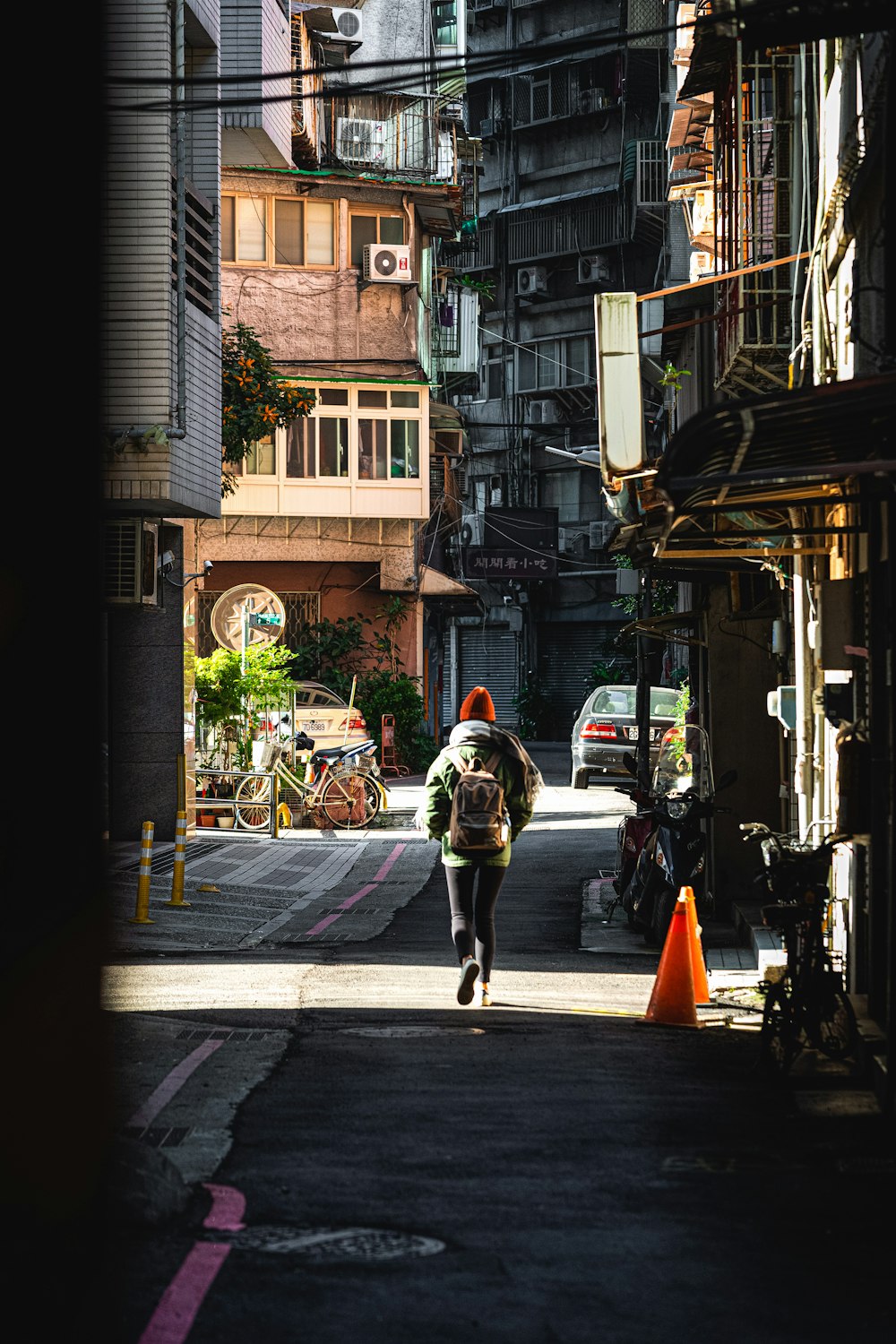 a man walking down a street next to tall buildings