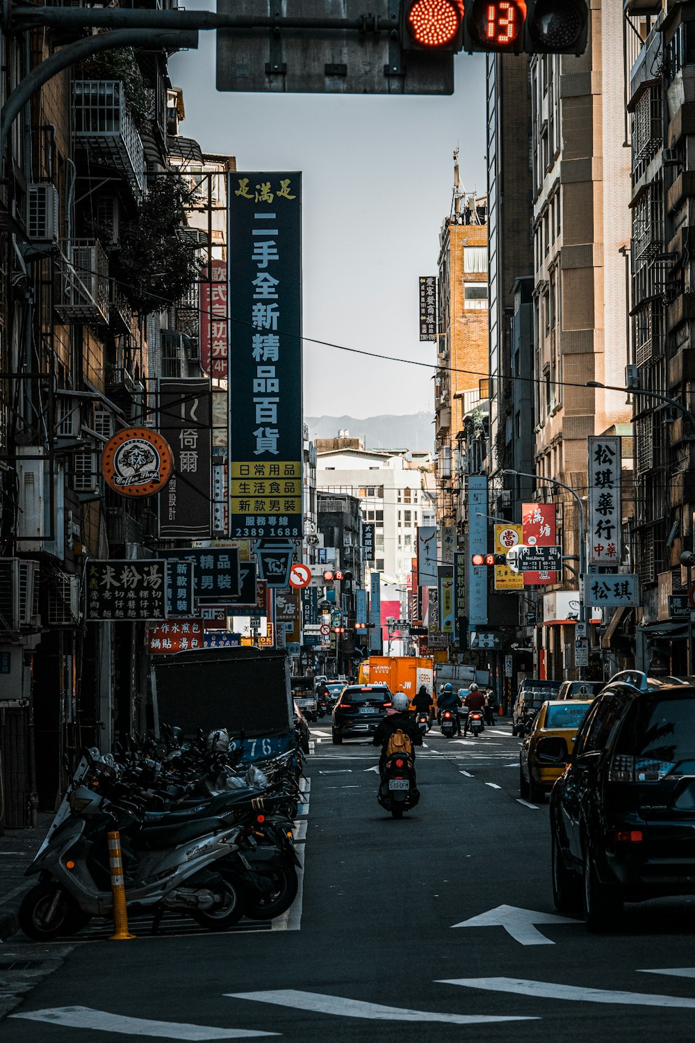 a city street filled with traffic next to tall buildings