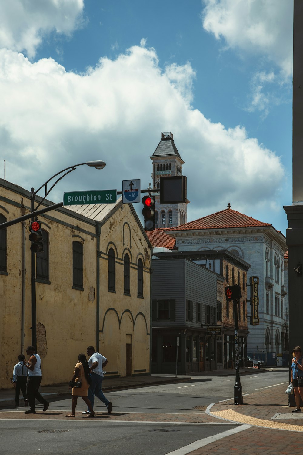 a group of people crossing a street in front of a tall building