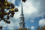 Laurencekirk church with its tall steeple reaching toward soft clouds.