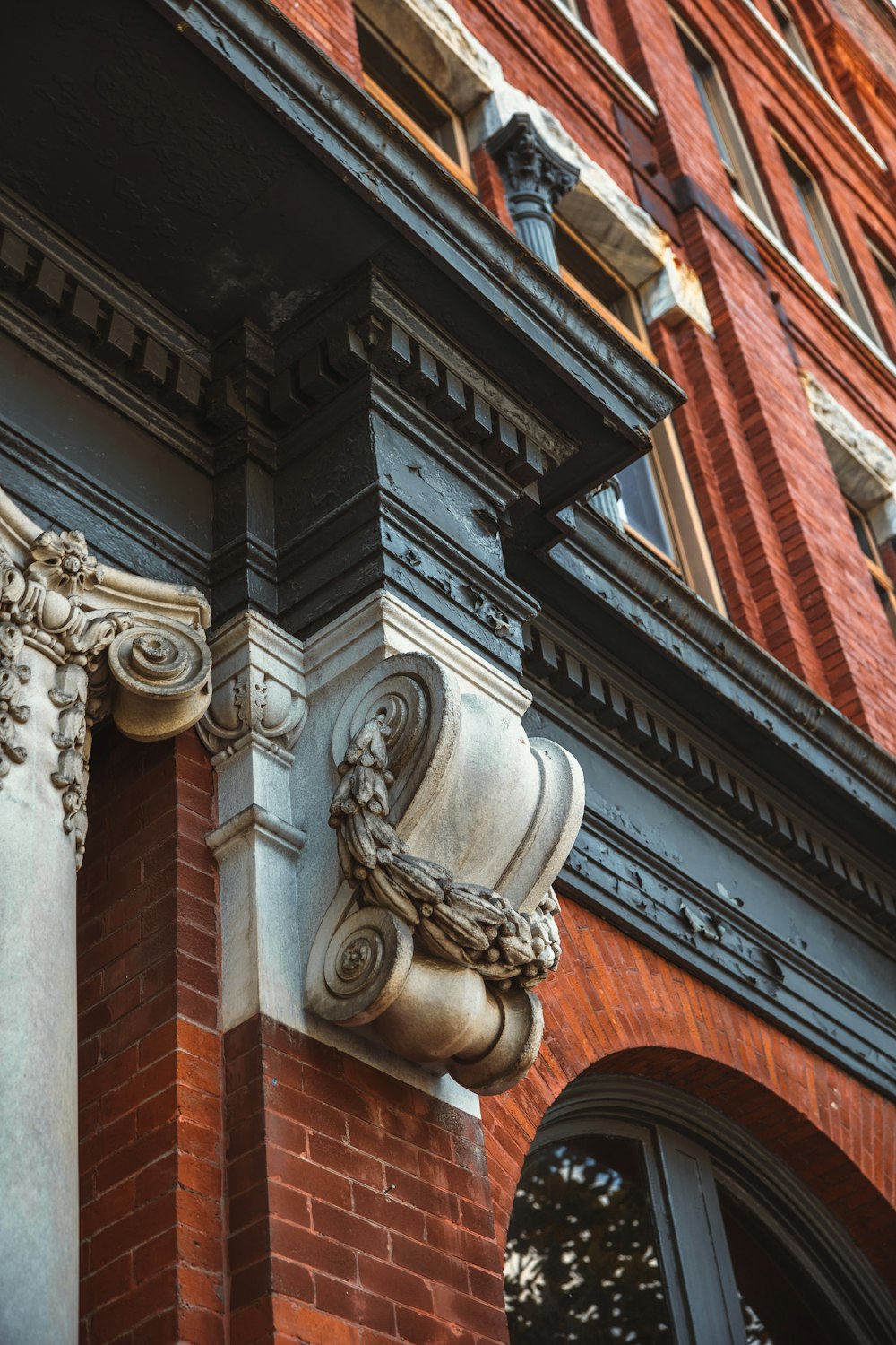 a close up of a brick building with a decorative gargoyle