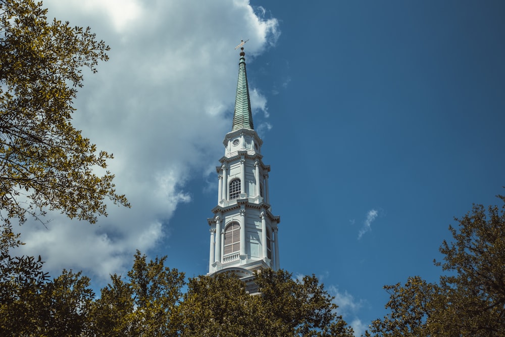 a tall white steeple with a clock on it