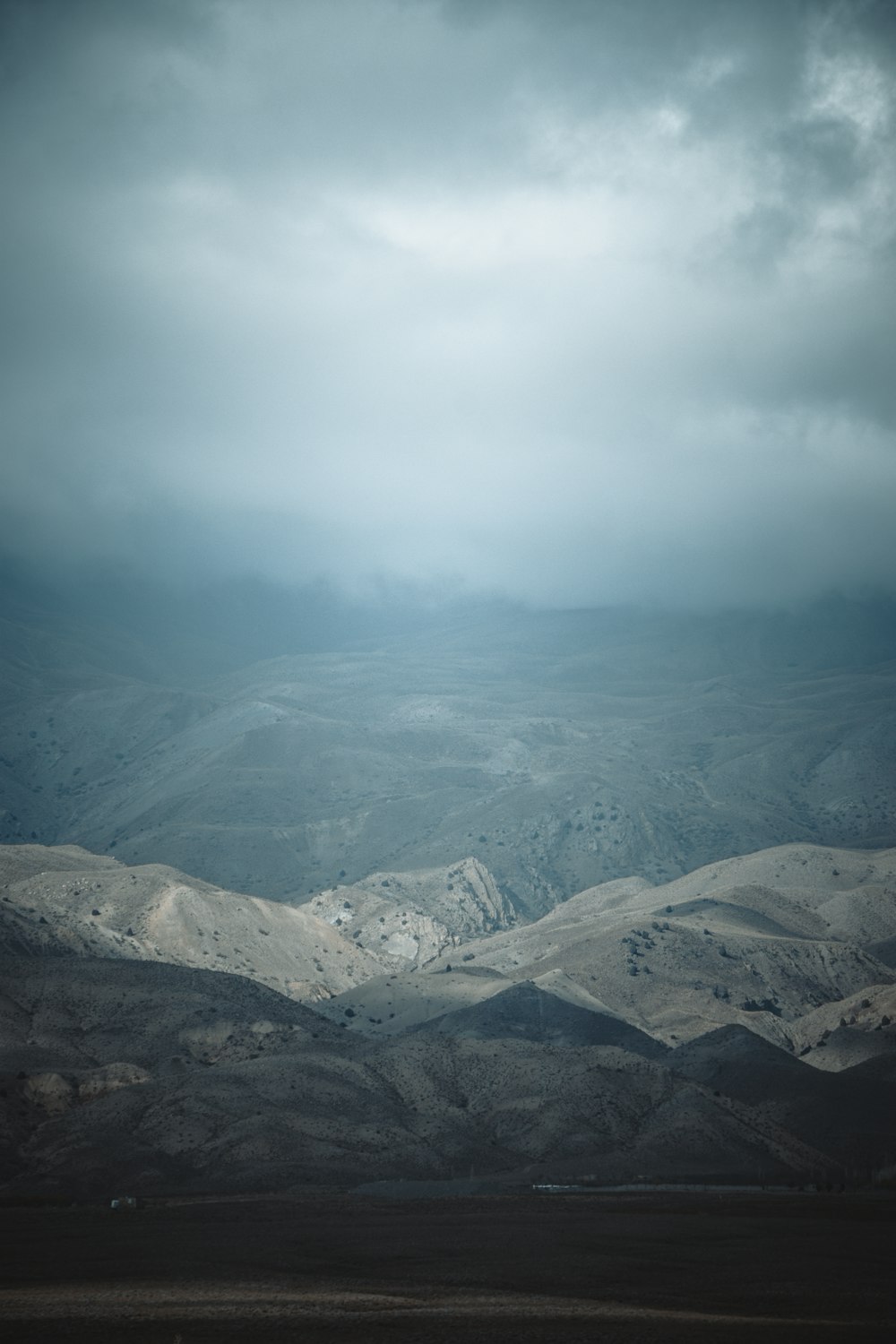 a mountain range with a cloudy sky in the background