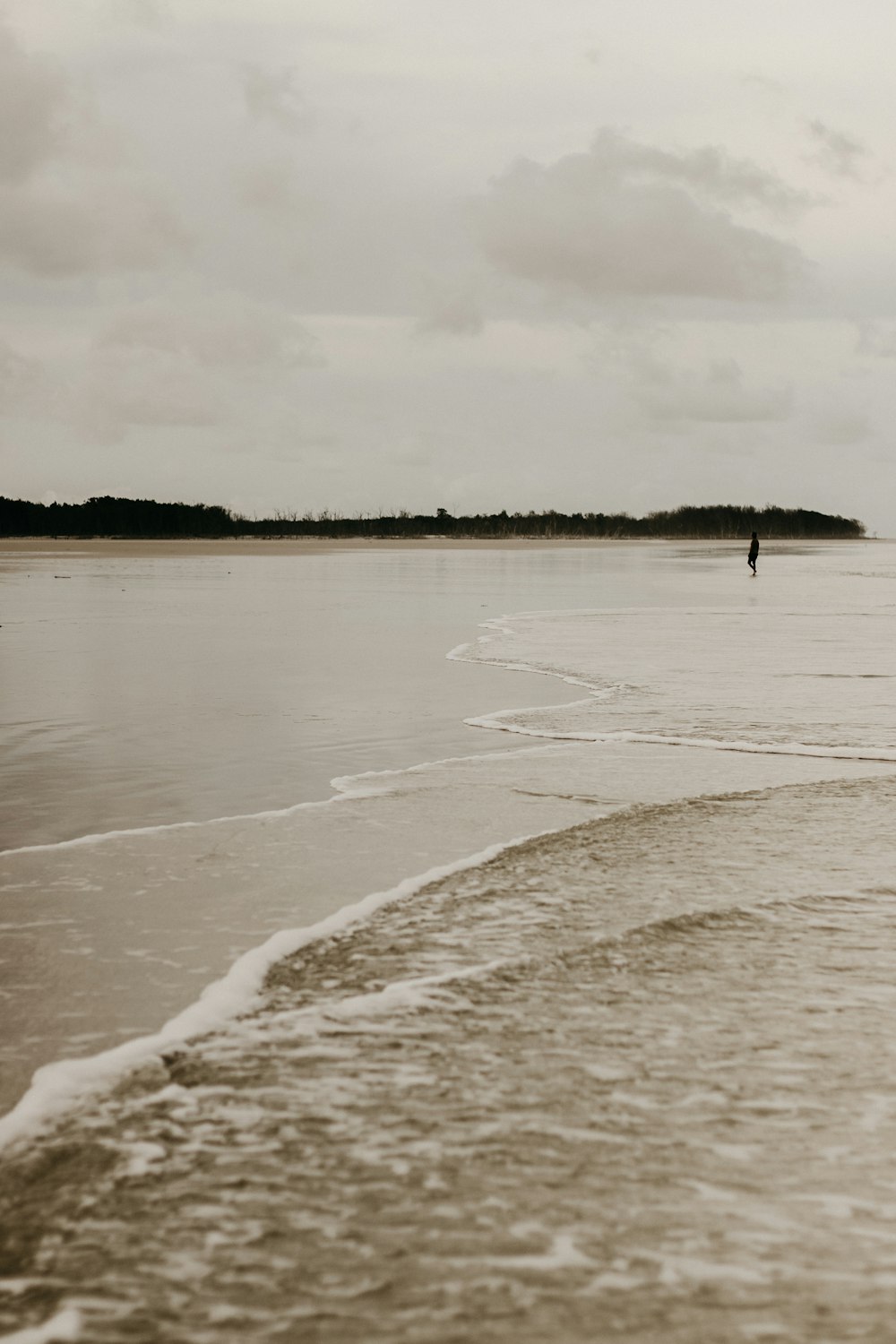 a person walking on the beach with a surfboard