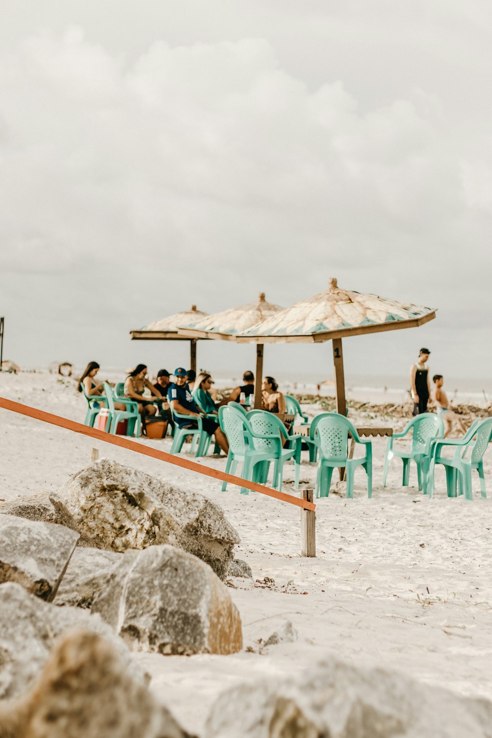 a group of people sitting at a table on a beach