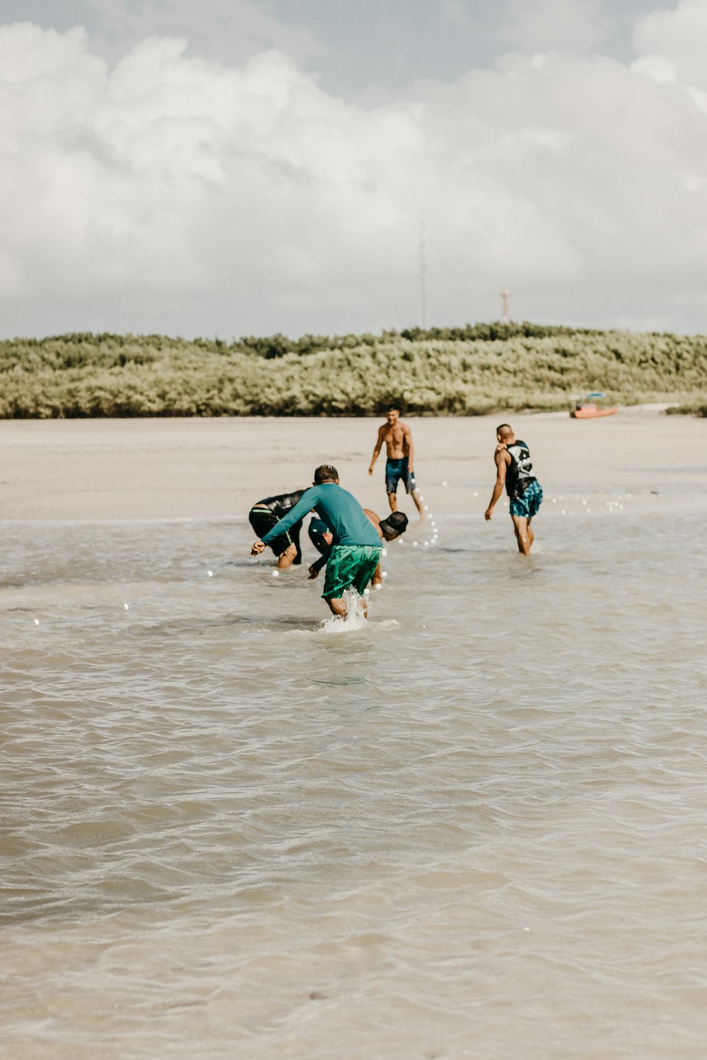 a group of people walking across a sandy beach