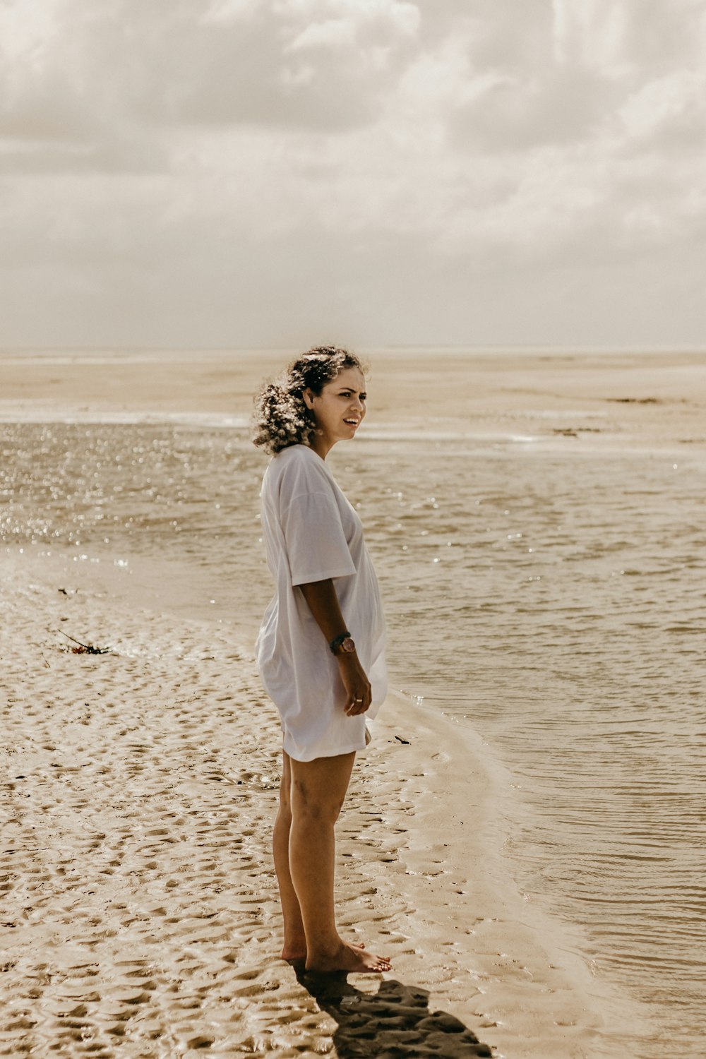 a woman standing on top of a sandy beach