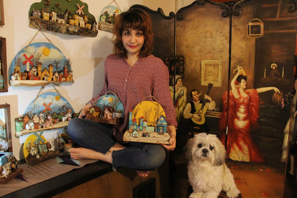 a woman sitting on a table with a dog