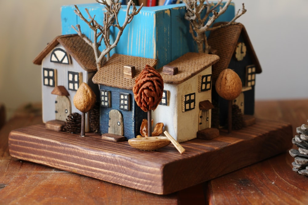 a wooden stand with a house and trees on it
