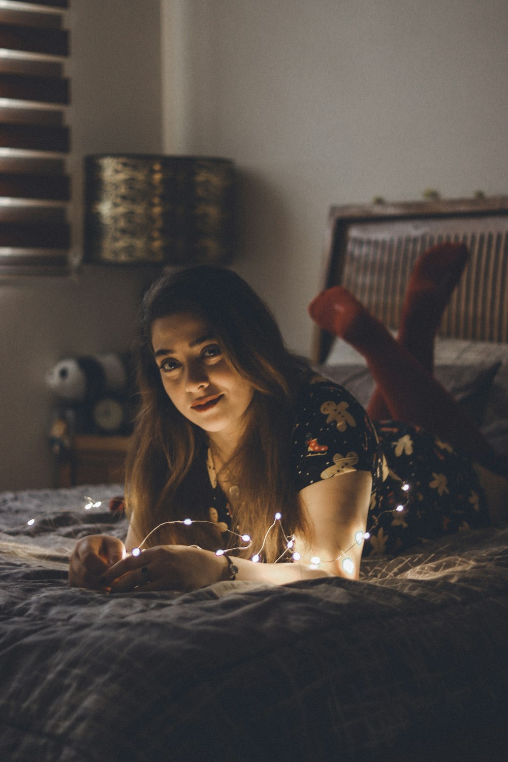 a woman laying on a bed holding a lit candle