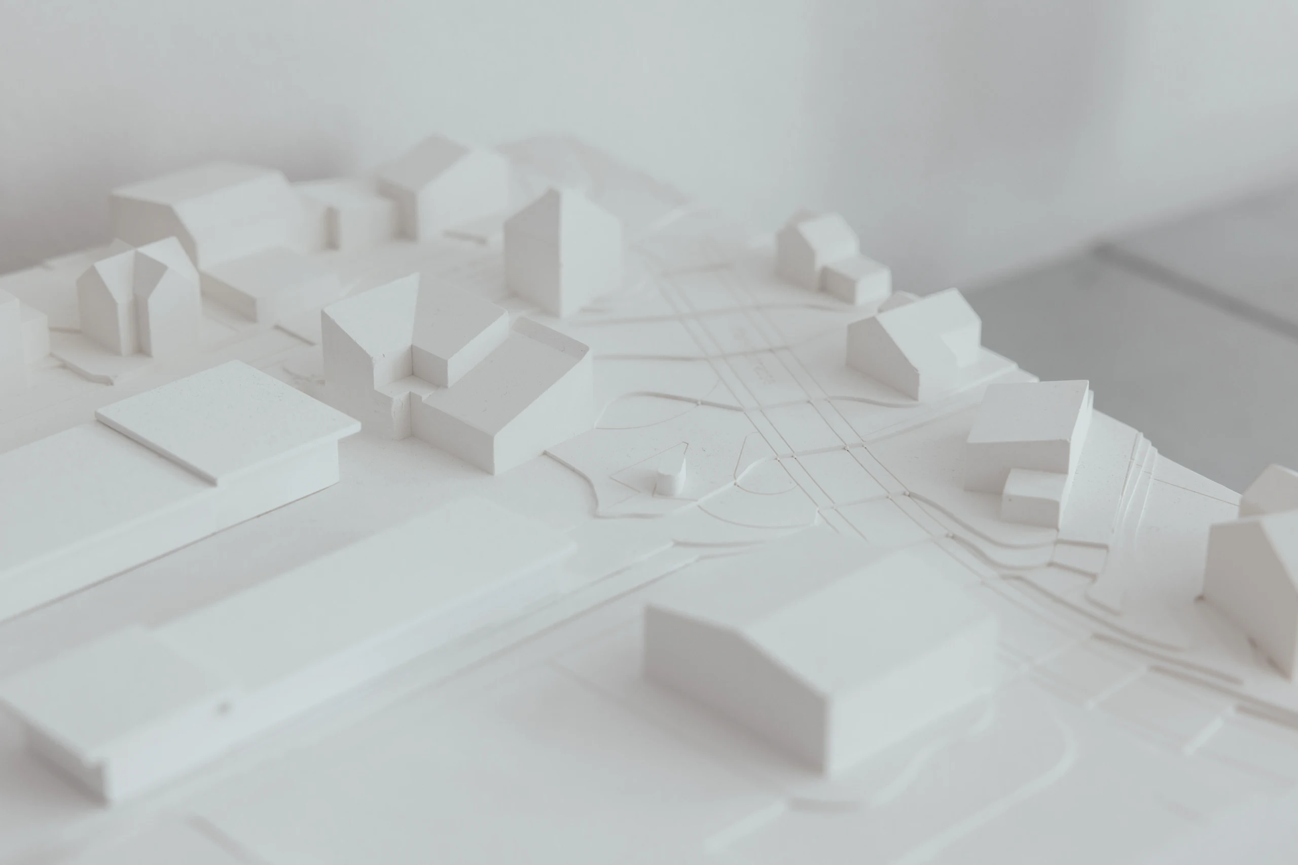 A white massing model of a cluster of buildings