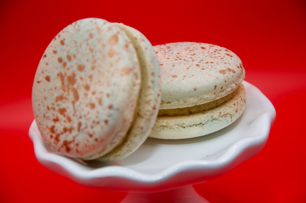 a white plate topped with two cookies on top of a red table