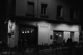 A cozy urban street corner with friends chatting and laughing under warm streetlights