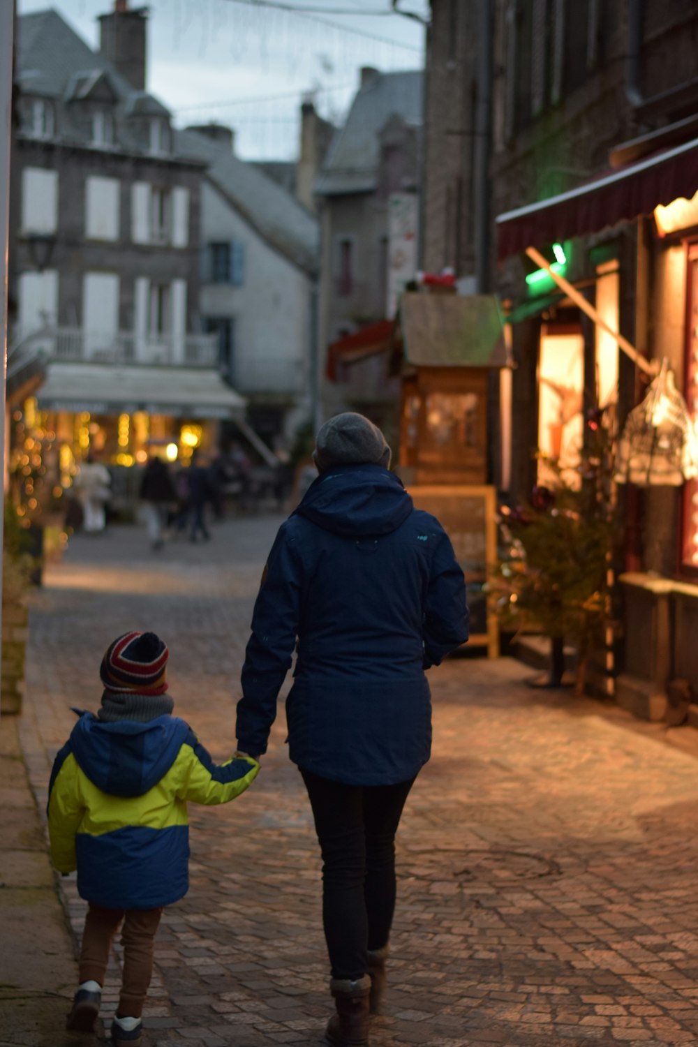 a woman and a child walking down a street