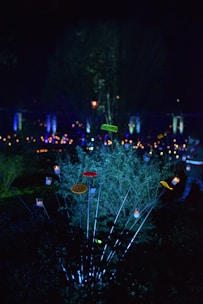 Solar-powered LED garden stakes glowing softly among blooming flowers at dusk.