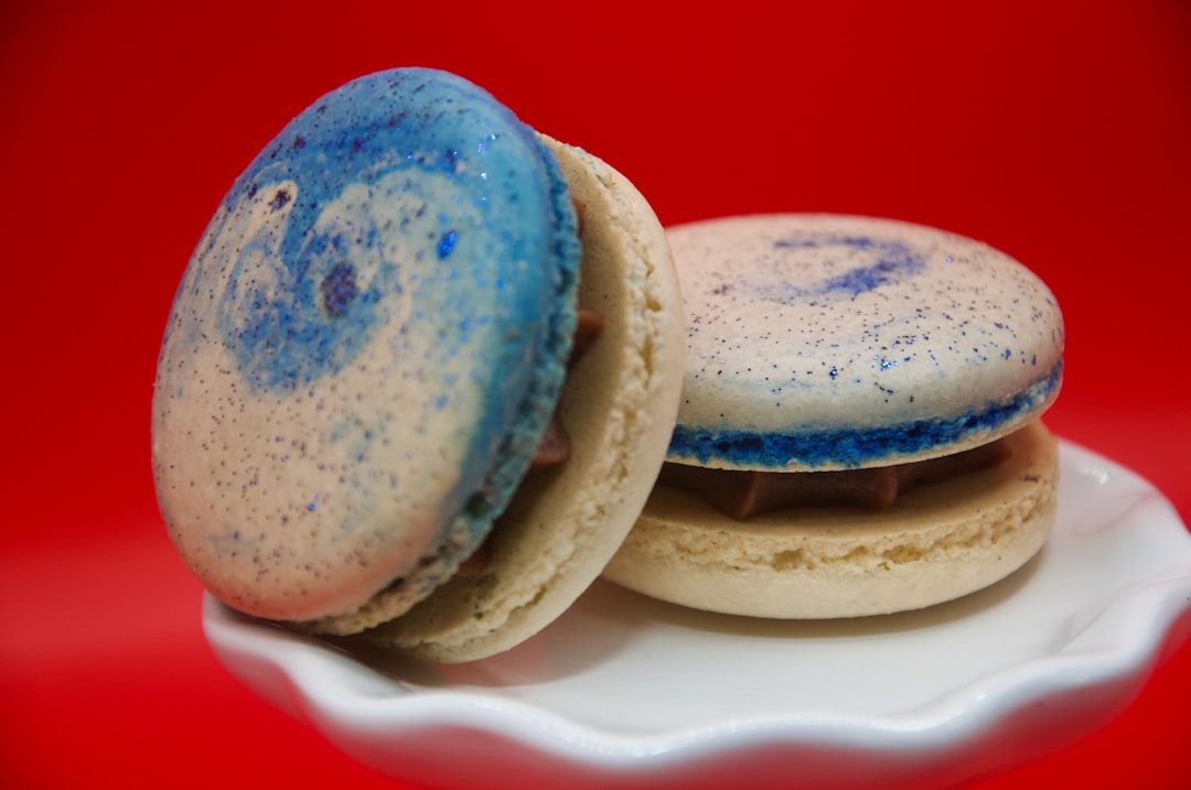 a couple of cookies sitting on top of a white plate, Brigadeiro Macarons