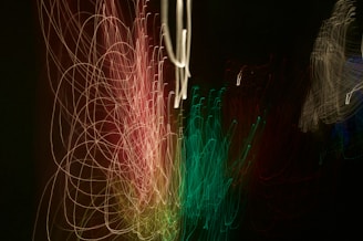 Abstract experimental video art with layered visuals of light trails and grainy textures on a dark background.