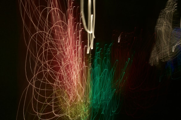 Abstract experimental video art with layered visuals of light trails and grainy textures on a dark background.