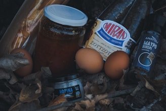 a jar of honey, eggs, and other items are on the ground