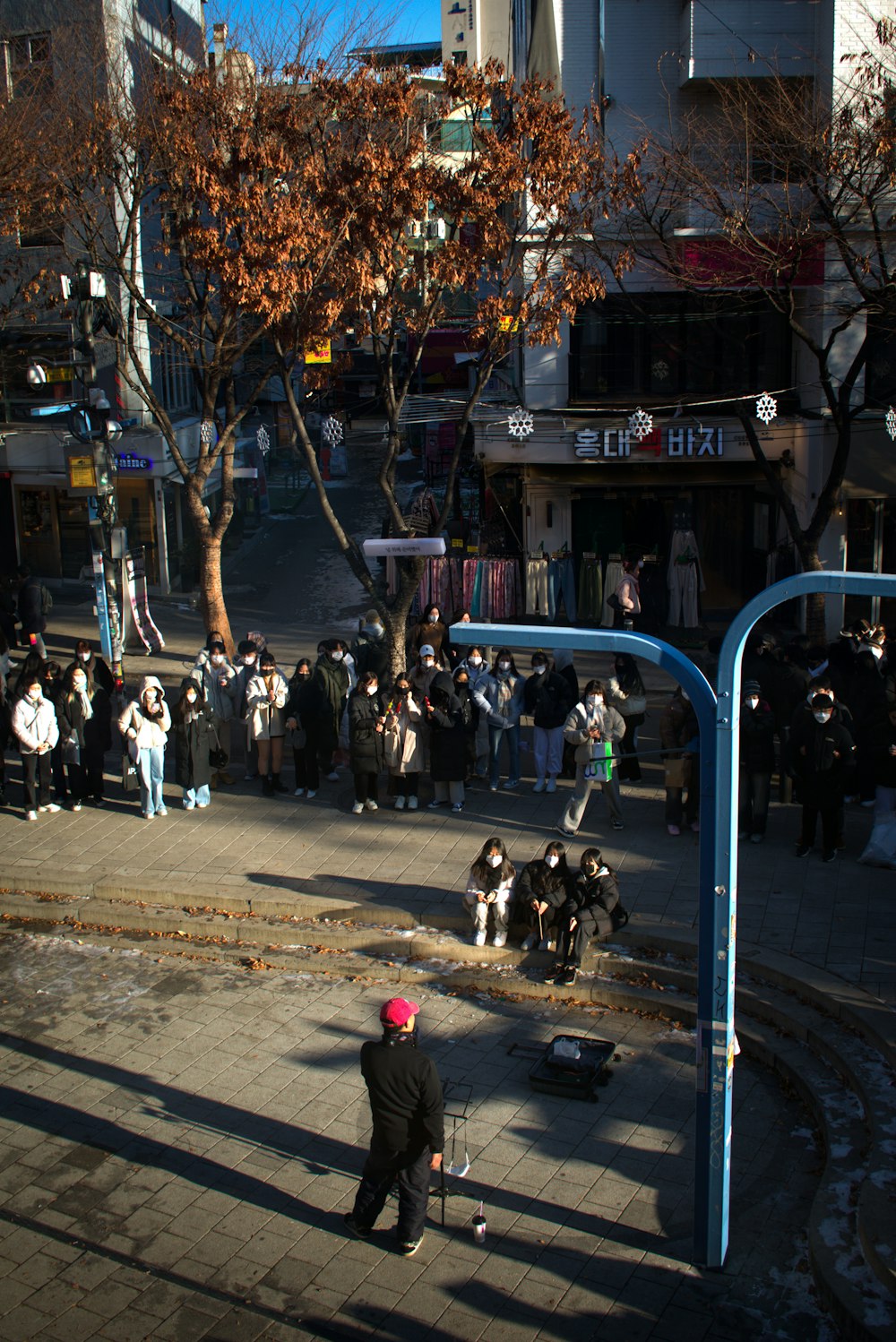 a group of people standing on a street corner