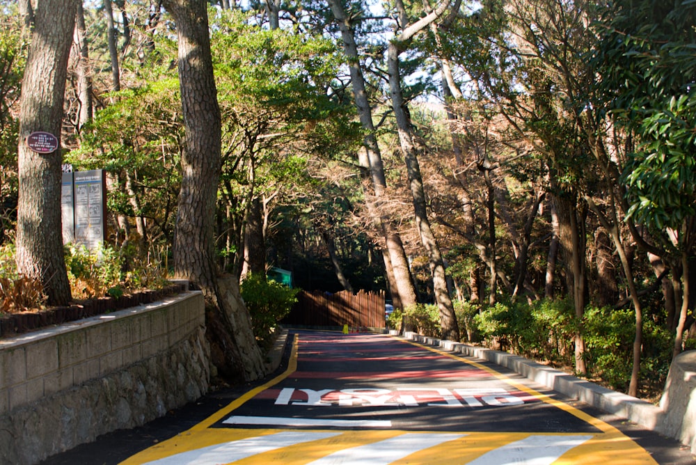 a yellow and white crosswalk in a wooded area