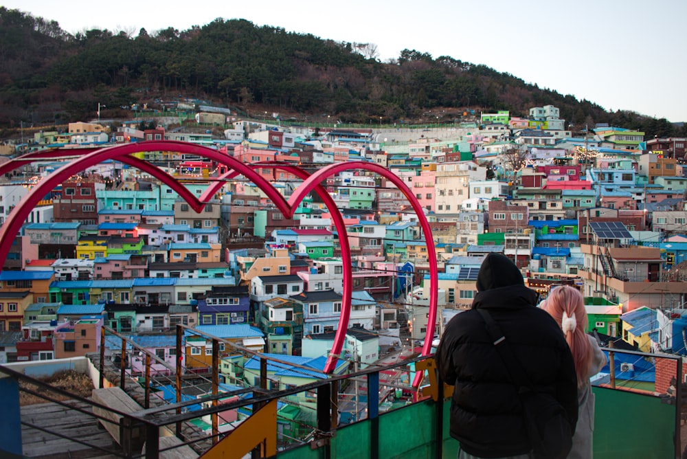 a man standing on top of a building next to a hillside