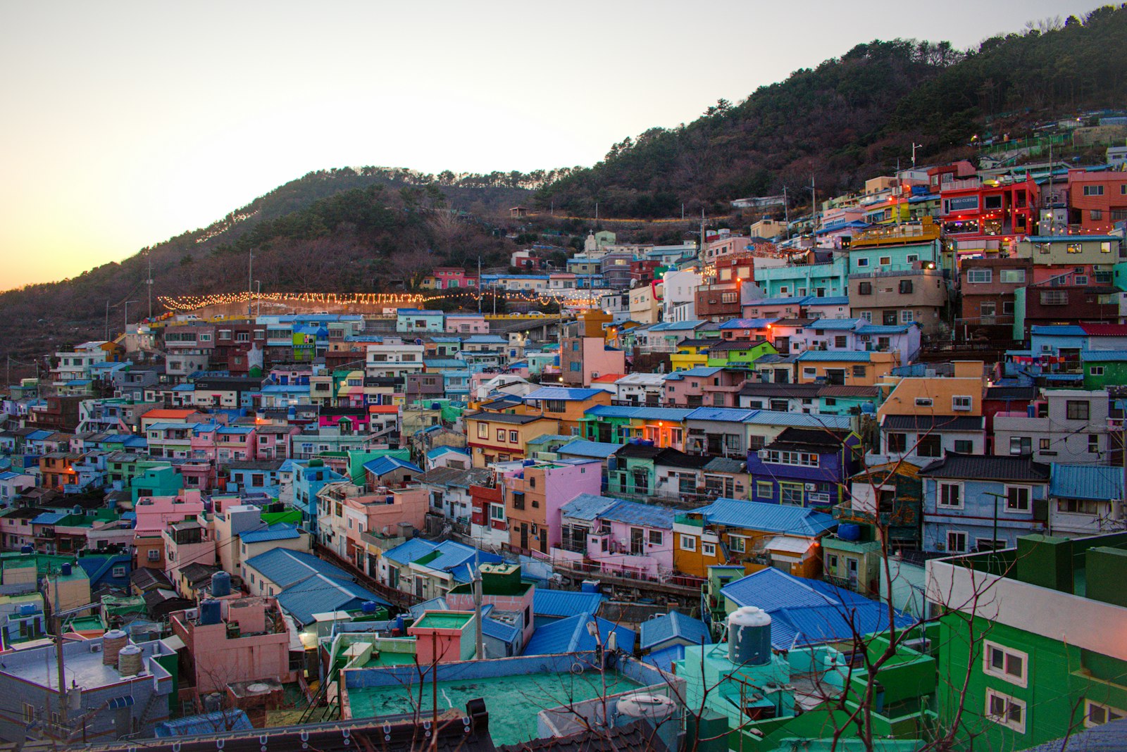 Pastel houses stacked up the hillside at Gamcheon Culture Village in Busan at sunset