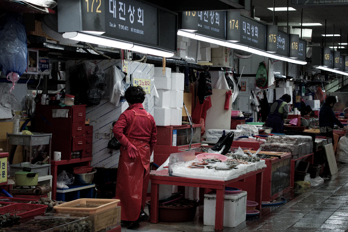 A vendor working at a stall inside Jagalchi Fish Market in Busan