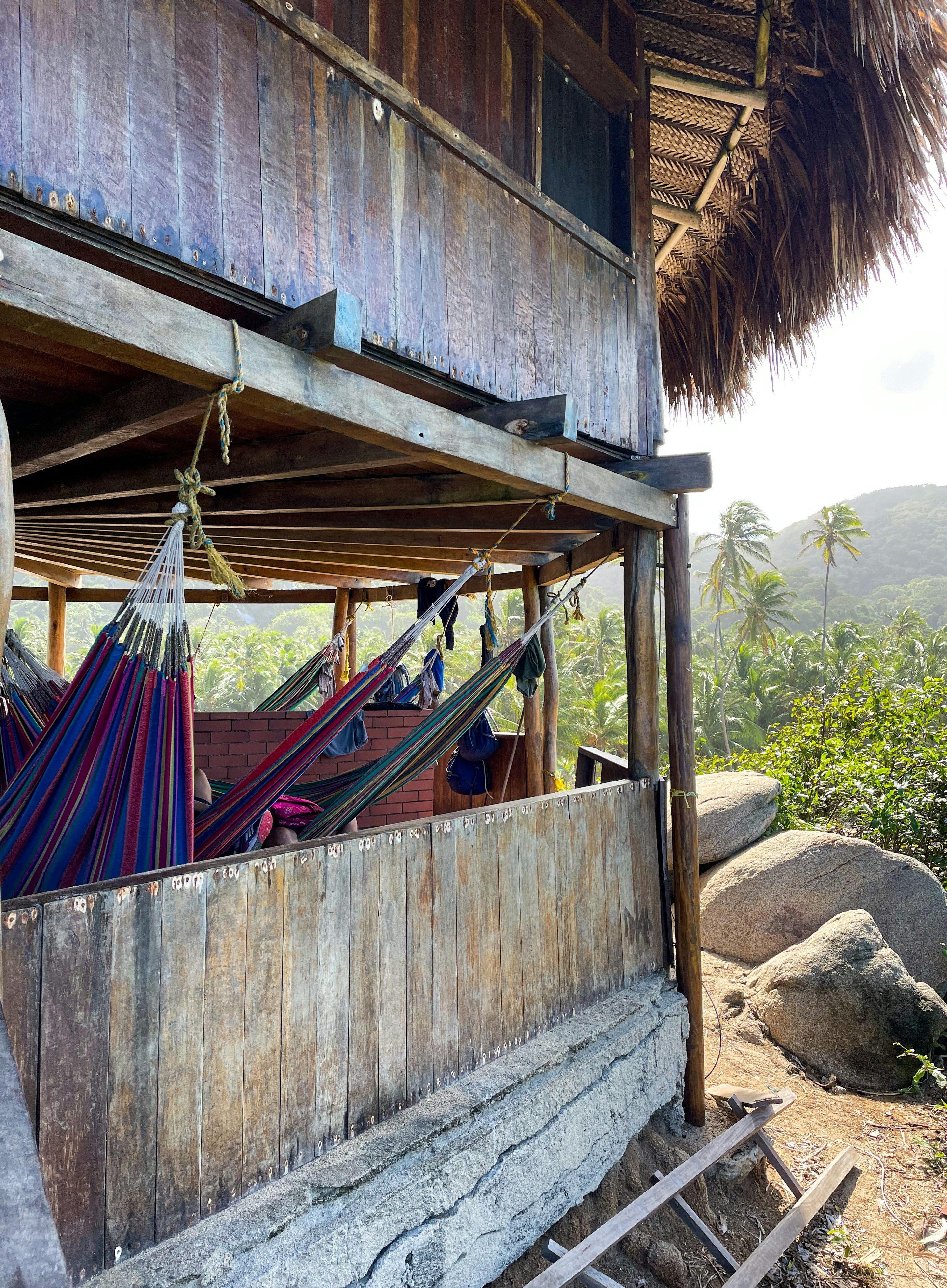Outdoor wooden terrace with hammock overlooking tropical jungle canopy