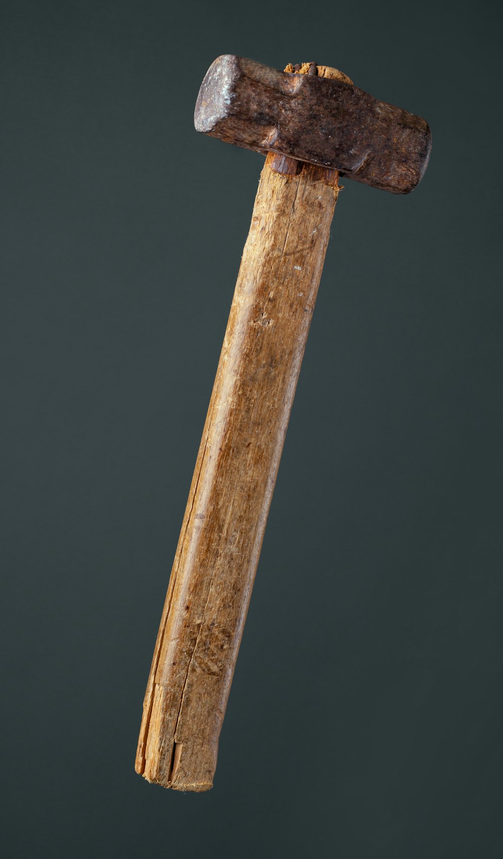 an old hammer with a wooden handle on a black background