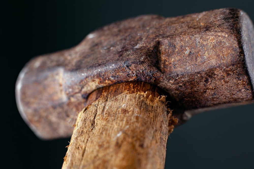 eine Nahaufnahme eines Hammers, der auf ein Stück Holz trifft