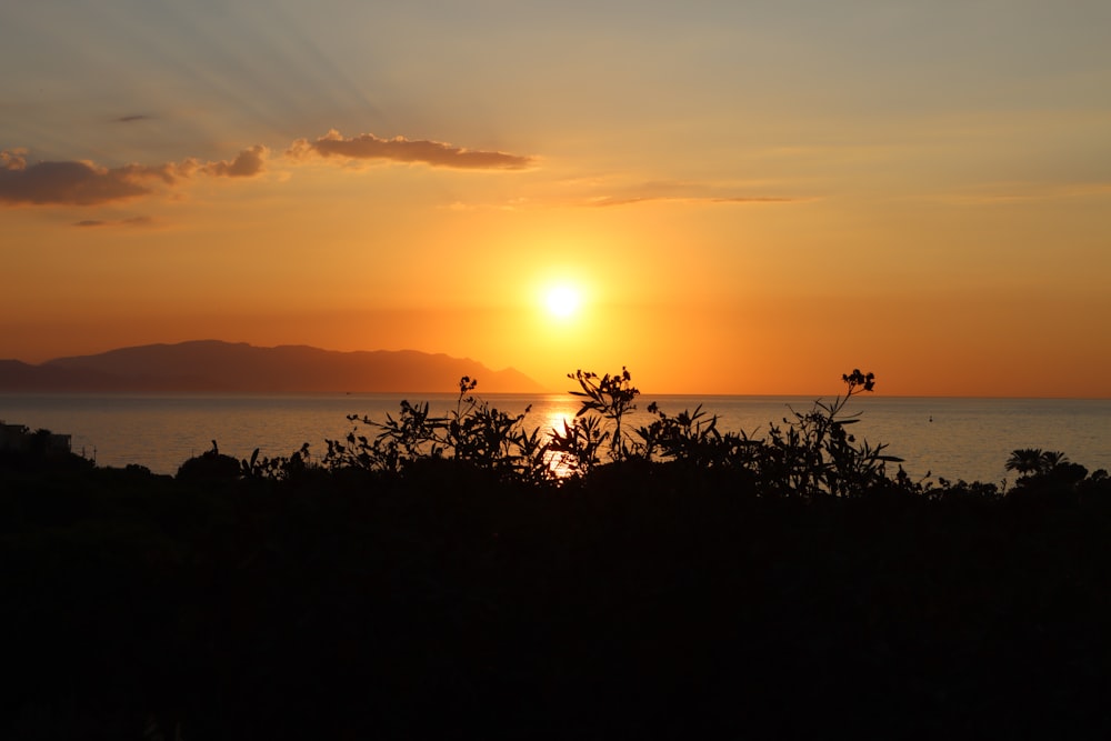 the sun is setting over a body of water