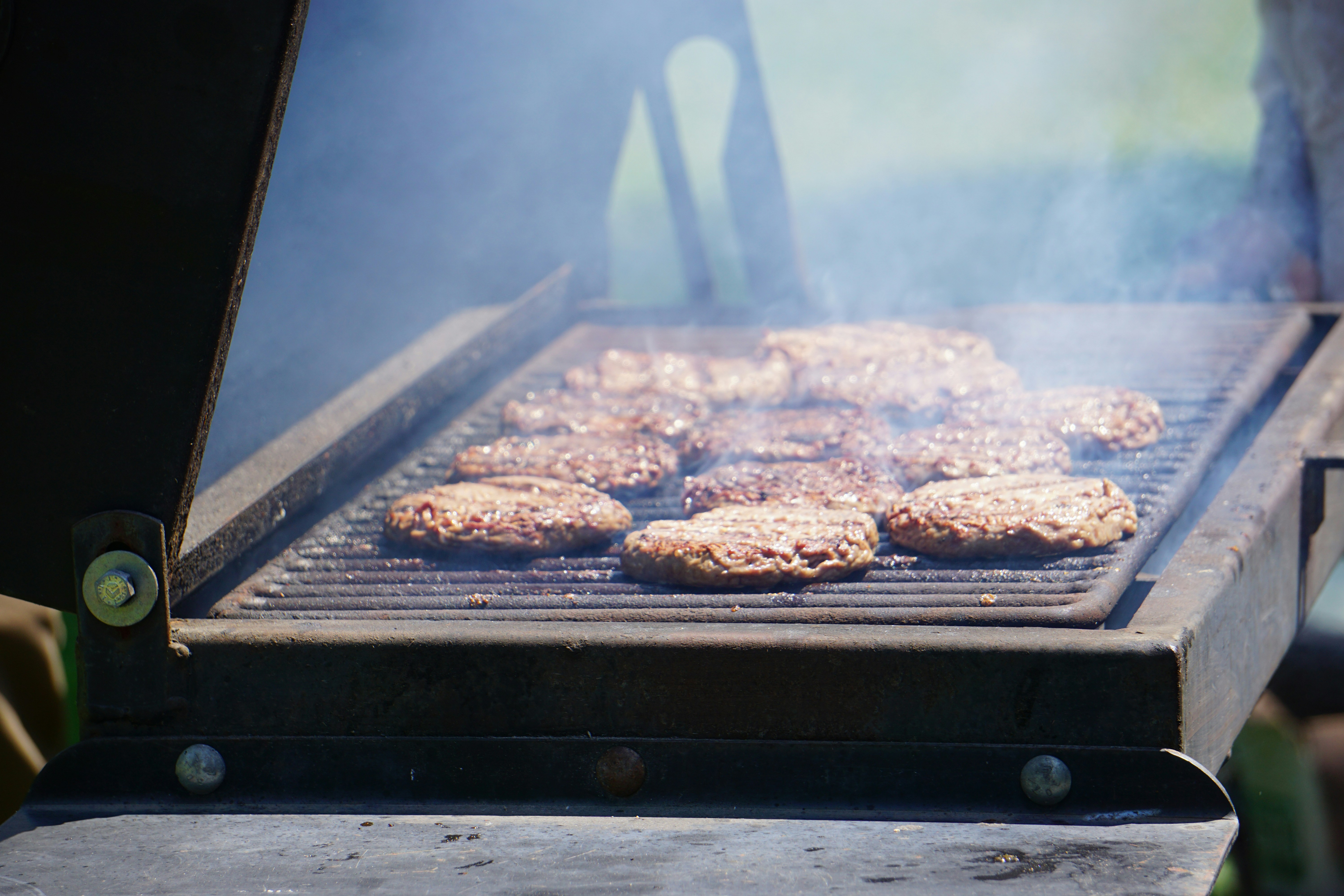 a grill with hamburgers cooking on it