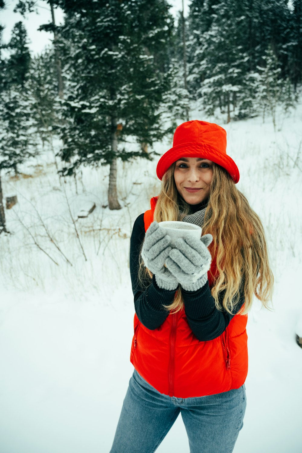 a woman in a red jacket and red hat holding a cell phone